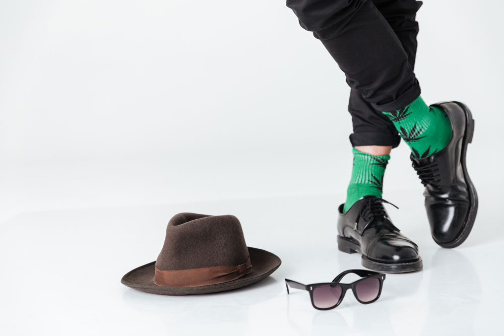 cropped image man standing floor near hat sunglasses