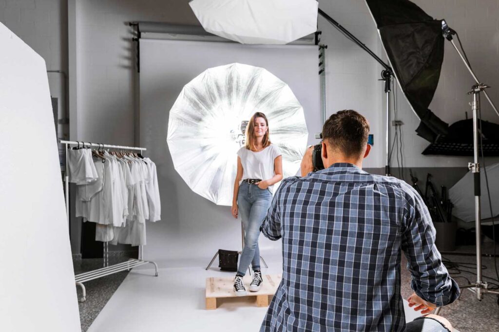 man taking photo woman model studio